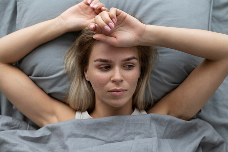 a woman lying on bed having trouble sleeping